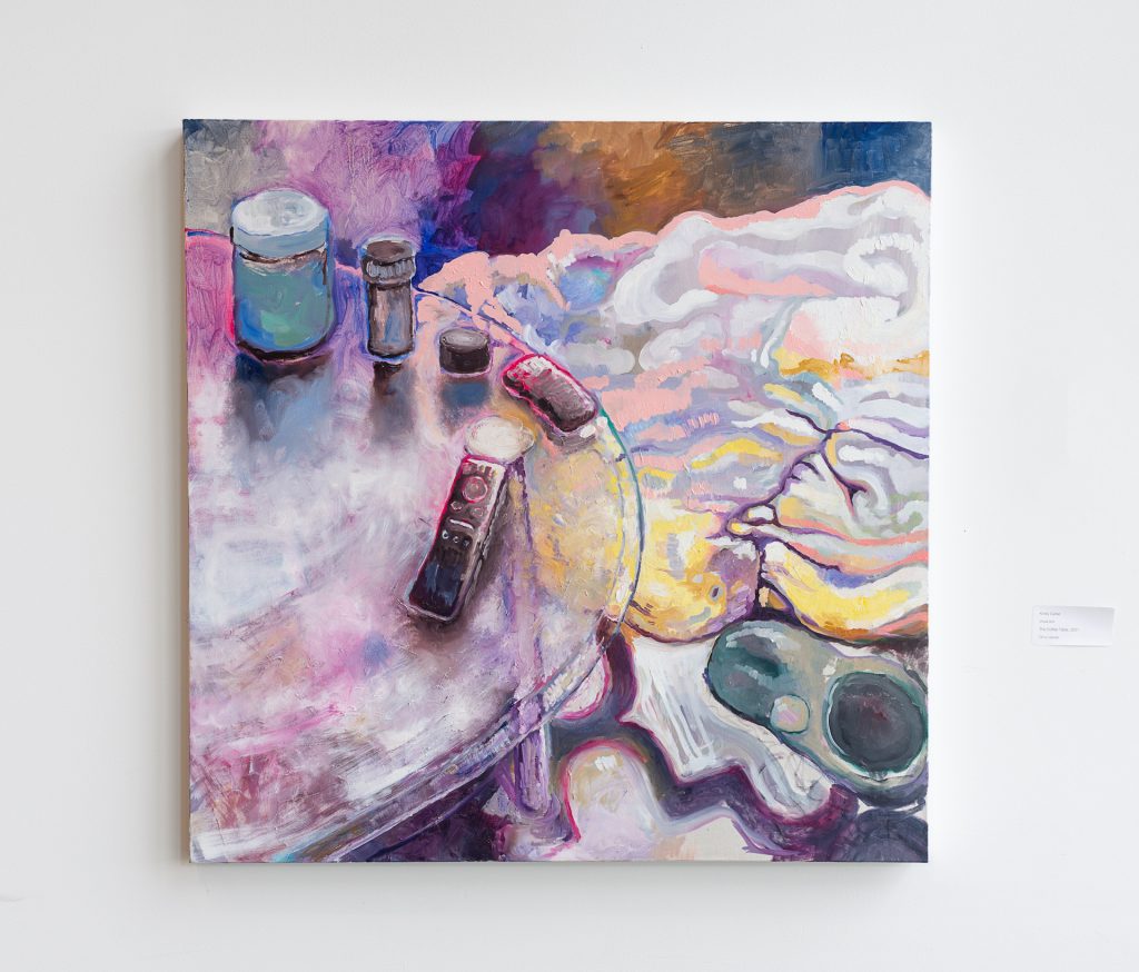 Oil painting depicting a glass coffee table with pill bottles, jars, and TV remotes on it. The ground is covered in colourful pink, purple, yellow and peach brushstrokes. 