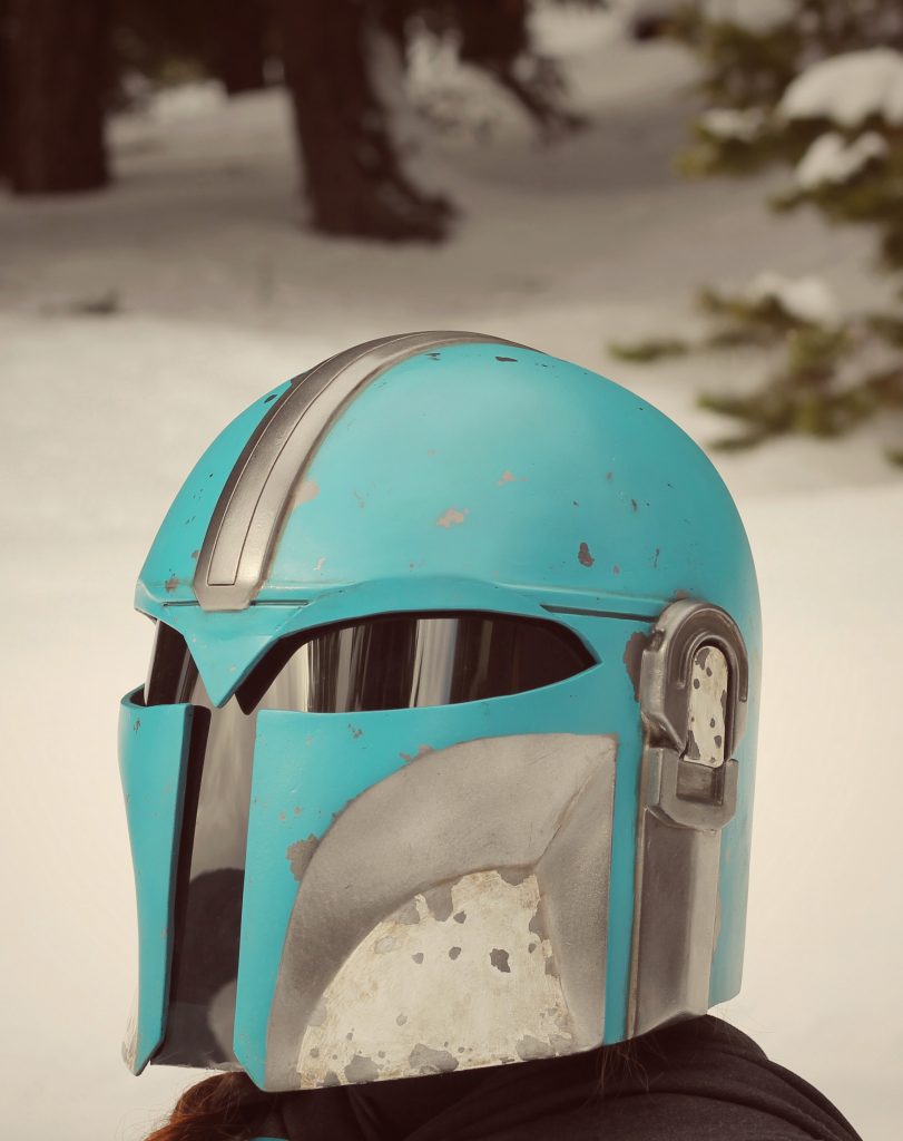 Close up of teal and silver helmet. Bright and snowy background. 